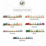 A customization options graphic for a personalized wooden name train, showing the word 'NOAH' spelled out in train car shapes with different color options labeled 'Pastel Boy', 'Pastel Rainbow', 'Khaki', 'Rainbow', 'Princess', 'Minty', and 'Baby Blue'.