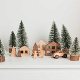 Wooden Christmas village scene with trees and houses on a white background