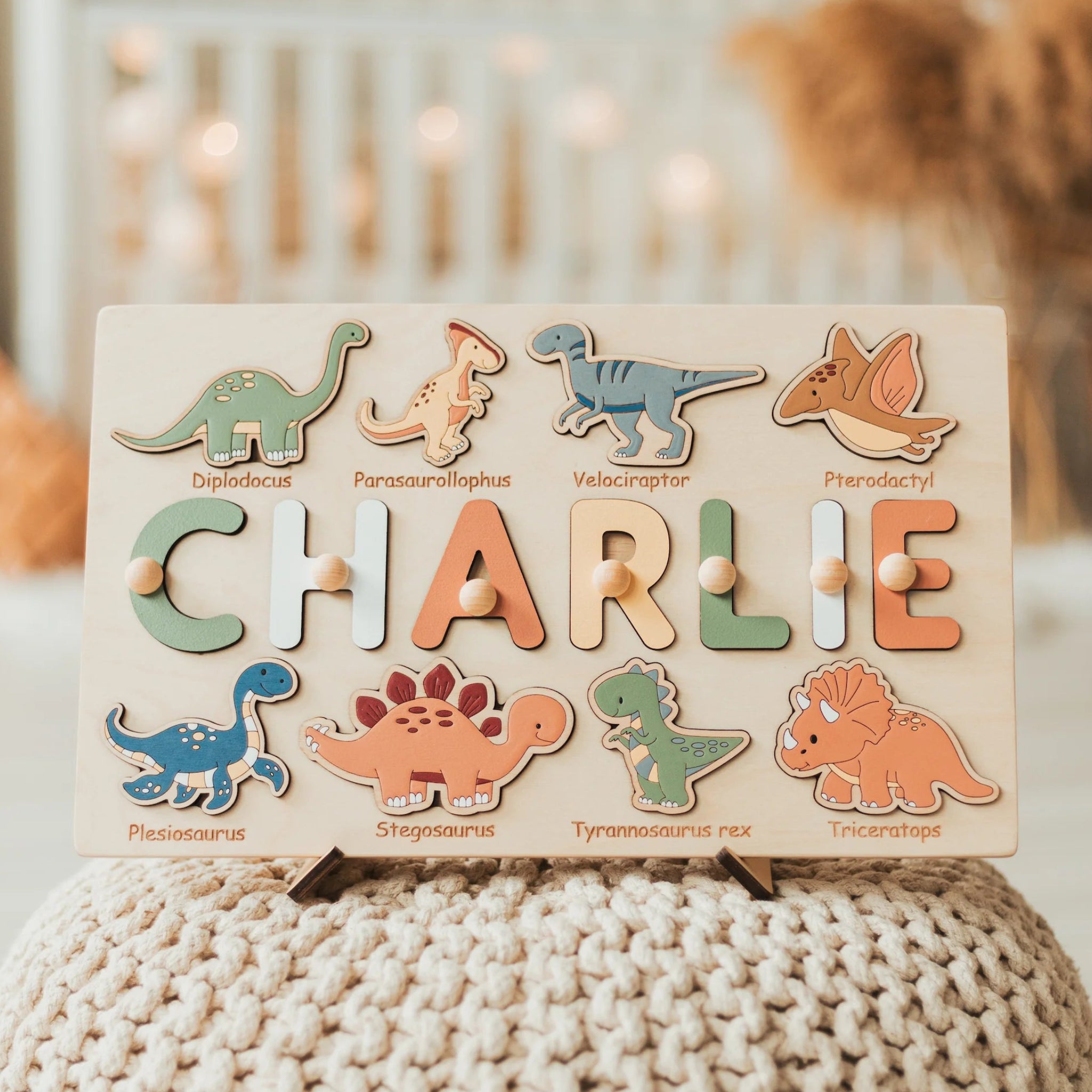Wooden name puzzle with dinosaur designs on a textured surface