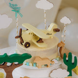 Wooden toy plane cake topper on a desert cactus themed cake