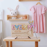 Wooden name plaque with colorful letters on a stand in a nursery setting