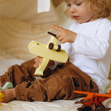 Child playing with a toy airplane on a bed