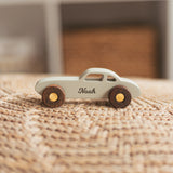 Personalized wooden coupe car with the name Noah on a knitted blanket