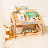 Wooden children's bookshelf with books and toys, personalized with 'NOAH'S LIBRARY'.