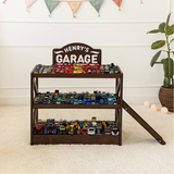 Dark wood personalized toy car garage named Henry's Garage, three tiers filled with toy cars and a ramp in a nursery