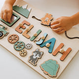Wooden name board with letters spelling 'Elijah' and various shapes on a light background.