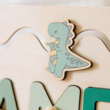 Wooden dinosaur name board piece on a light background.