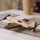 Personalized natural wood airplane toy with engraved name Oliver on runway background