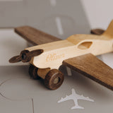Natural wood airplane toy with engraved name Oliver and airplane icon background