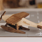 Wooden airplane model with name engraving on a blurred background