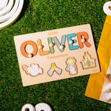 Wooden name puzzle with colorful letters spelling 'OLIVER' on a grassy background