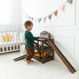 Toddler playing beside a dark wood personalized toy car garage named Henry's Garage