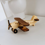 Wooden toy airplane with engraved name on a white surface