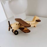 Two-tone wood biplane toy with engraved name James, full view on white background