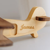 Close-up of natural wood airplane toy wing with engraved name James