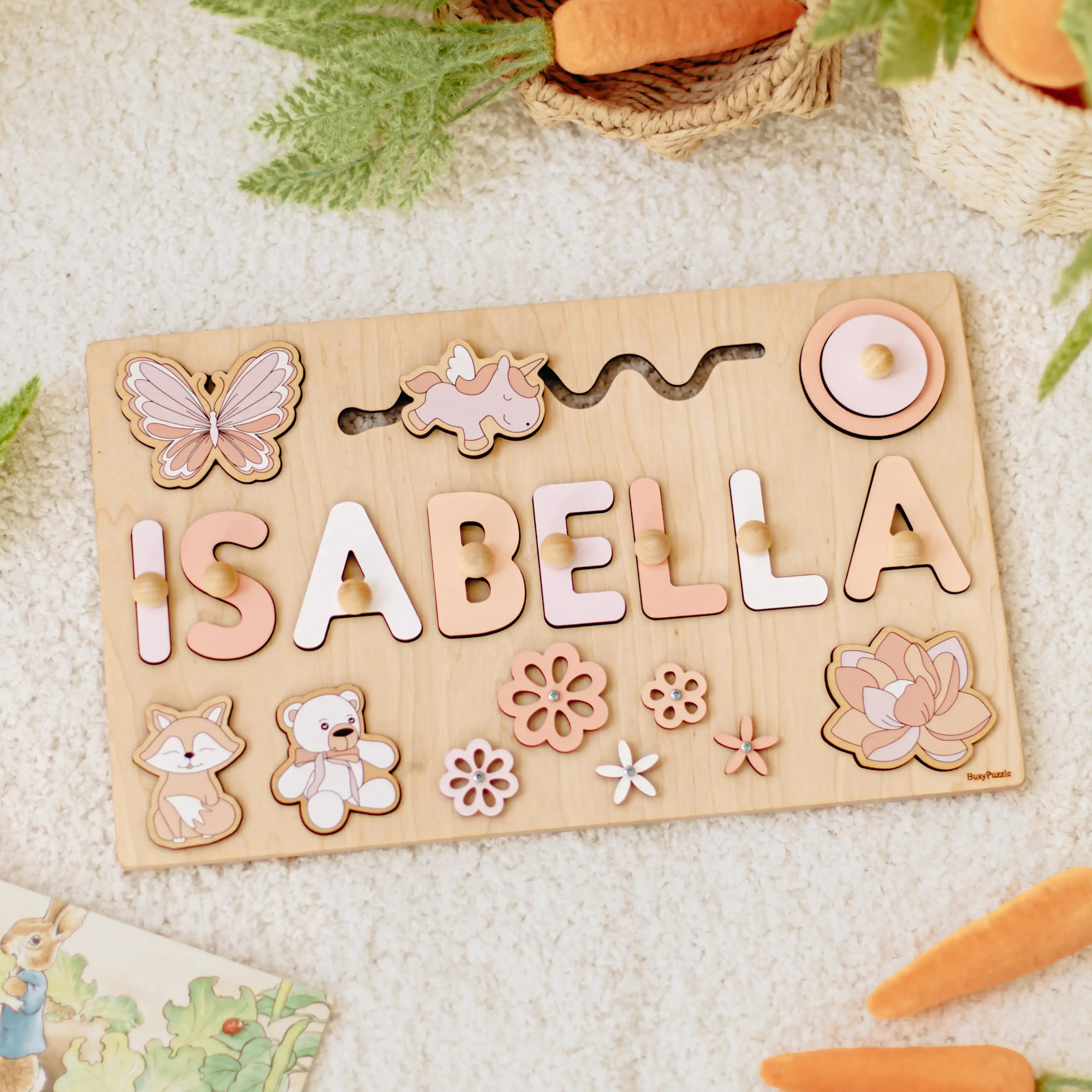 Wooden name board with additional elements on a white fluffy surface.