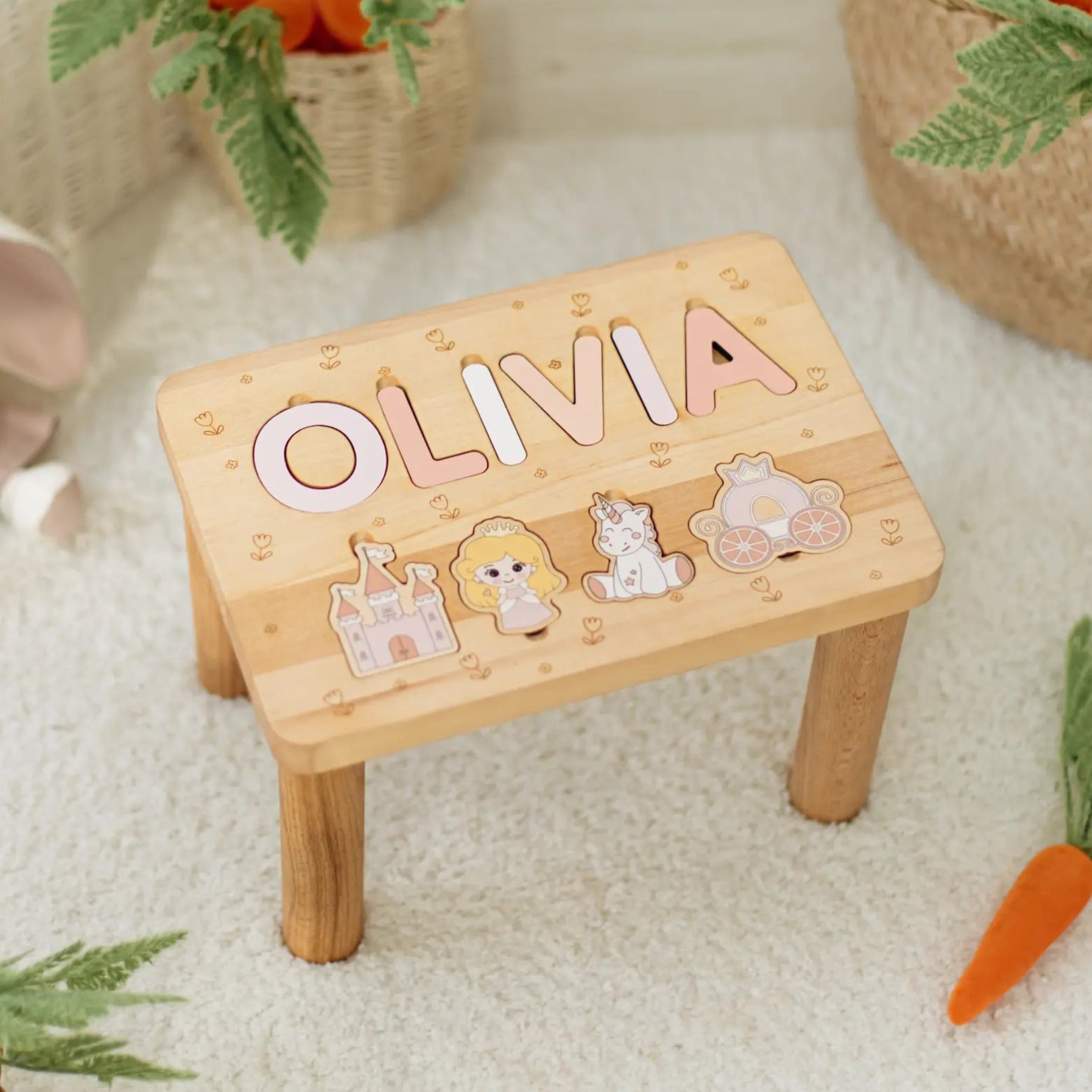 Wooden step stool with name letters and puzzle illustrations on a soft surface with toys and carrots.