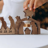 Child placing the star on a dark wood Nativity Scene above the advent calendar days 22 to 24