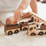Child playing with wooden toy trucks on a carpeted floor
