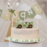Green wooden rally car used as a first birthday cake topper with cloud decorations